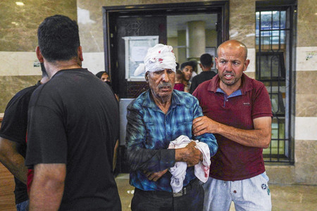 ９日、パレスチナ自治区ガザ南部ハンユニスの病院を訪れる負傷者（ＡＦＰ時事）