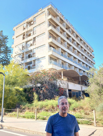 キプロス島東部バローシャにあるホテルの廃虚前で、昔の思い出を語る元住民アンドレアス・ロルドスさん＝６月５日