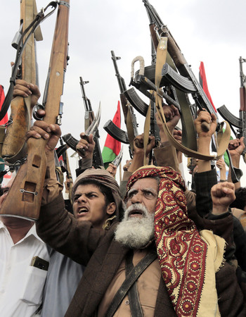銃を掲げ、反米・反イスラエルの抗議活動を展開するイエメンの親イラン武装組織フーシ派支持者＝１９日、首都サヌア（ＥＰＡ時事）