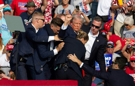銃撃されたトランプ前米大統領を取り囲み、演壇から降ろす警護官＝１３日、ペンシルベニア州バトラー（ＡＦＰ時事）