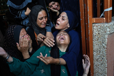 ２２日、パレスチナ自治区ガザ南部ハンユニスのナセル病院前で、犠牲者を悼み泣く女性ら（ＡＦＰ時事）