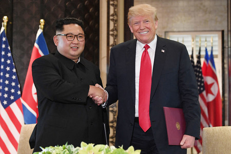 初の米朝首脳会談で握手するトランプ前米大統領（右）と北朝鮮の金正恩朝鮮労働党総書記＝２０１８年６月、シンガポール（ＡＦＰ時事）