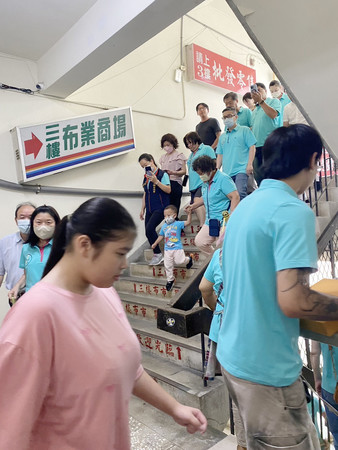２３日、台北市の市場で防空避難訓練「万安演習」に参加し地下の避難所に向かう人々