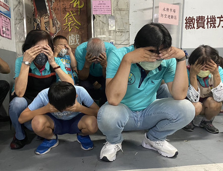 ２３日、台北市の市場で防空避難訓練「万安演習」に参加する人々