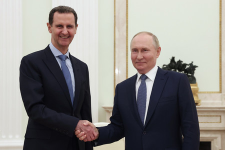 ２４日、モスクワを訪問したシリアのアサド大統領（左）と握手を交わすロシアのプーチン大統領（ＥＰＡ時事）
