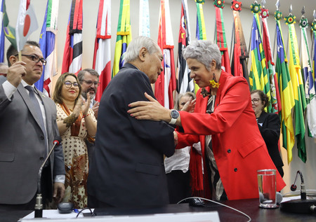 ブラジル政府による日本移民への謝罪後、日系人の代表と握手するアルメイダ恩赦委員長（右）＝２５日、ブラジリア