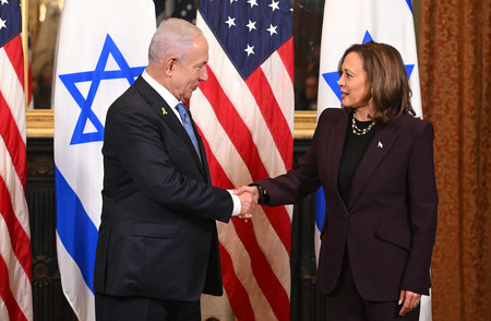 ２５日、ワシントンでイスラエルのネタニヤフ首相（左）と握手するハリス米副大統領（ＡＦＰ時事）