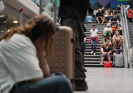 ２６日、パリのモンパルナス駅構内で座り込む人たち