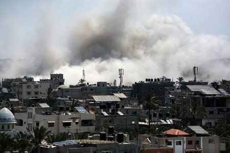 ２７日、パレスチナ自治区ガザ中部デイルバラで、イスラエル軍による空爆中に上がる煙（ＡＦＰ時事）