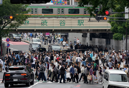 スクランブル交差点を渡る人たち＝東京都渋谷区（ＥＰＡ時事）