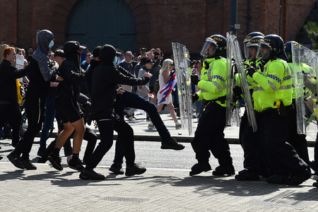 ３日、英西部リバプールに展開する警官隊（右）（ＡＦＰ時事）