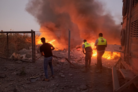 ２４日、イスラエルによる空爆を受けたレバノン南部の村に駆け付ける救助隊員ら（ＡＦＰ時事）