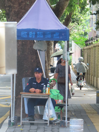 ２５日、日本人学校周辺で警備する中国当局者＝広東省深セン市