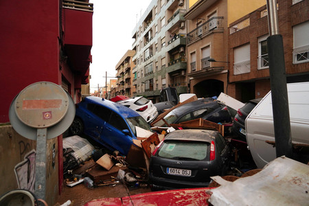 ３０日、スペイン東部バレンシア自治州で、洪水で流された路上の自動車（ＡＦＰ時事）