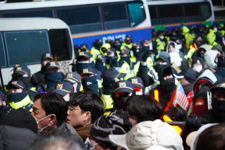 １５日早朝、ソウルの韓国大統領公邸付近で、移動する警官を阻止しようとする尹錫悦大統領の支持者ら