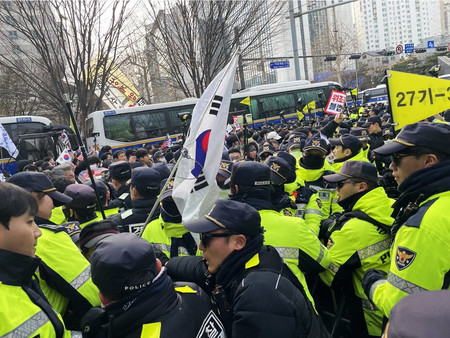 １８日、韓国のソウル西部地裁付近で、警官ともみ合う尹錫悦大統領の支持者ら