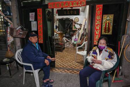 地震で被害を受けた自宅の外に座る住民＝２１日、台湾・台南市（ＡＦＰ時事）