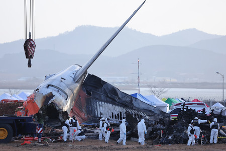 韓国南西部全羅南道の務安国際空港で発生した旅客機事故の現場を調べる警察の捜査チーム＝２０２４年１２月（ＥＰＡ時事）