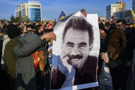 トルコの反政府武装組織クルド労働者党（ＰＫＫ）の創設者オジャラン氏の写真を掲げる支持者＝２月２７日、トルコ南東部ディヤルバクル（ＡＦＰ時事）