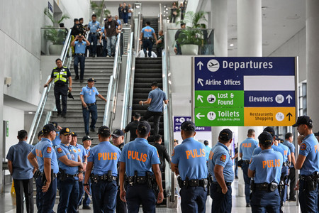 １１日、マニラの国際空港で、フィリピンのドゥテルテ前大統領の到着を待つ警察官（ＡＦＰ時事）