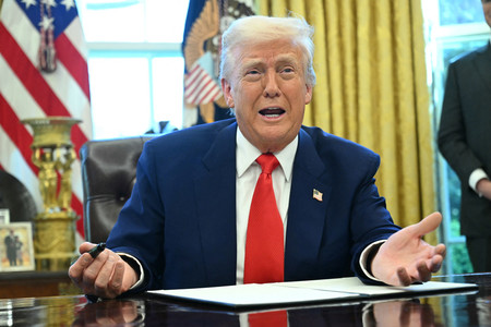 ホワイトハウスの執務室で、米大統領令に署名するトランプ氏=9日、ワシントン(AFP時事)