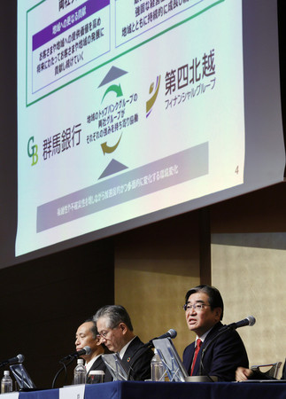 経営統合することで基本合意し、会見する(右から)群馬銀行の深井彰彦頭取と第四北越フィナンシャルグループの殖栗道郎社長=24日午後、東京都港区
