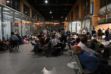 28日、大規模停電に巻き込まれ、スペイン南部コルドバの駅で夜を過ごす人々(AFP時事)