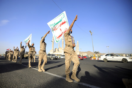 行進するイエメンの親イラン武装組織フーシ派の戦闘員ら=2月11日、サヌア(EPA時事)