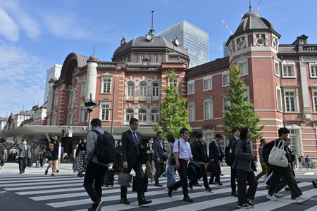 JR東京駅前の横断歩道を行き交う人たち(資料写真)
