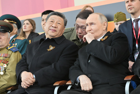 9日、モスクワの「赤の広場」で、対ドイツ戦勝80年記念の軍事パレードを観覧するロシアのプーチン大統領(中央右)と中国の習近平国家主席(中央左)(ロイター時事)