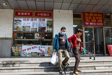 10日、中国・北京の食料品店と買い物客(EPA時事)