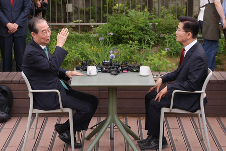 韓国の韓悳洙前首相(左)と与党「国民の力」の大統領予備選で勝利した金文洙前雇用労働相=8日、ソウル(EPA時事)