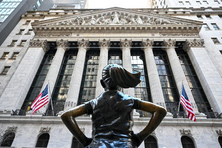 米ウォール街のニューヨーク証券取引所とその前に立つ「恐れを知らぬ少女」の像=4月8日、ニューヨーク(AFP時事)