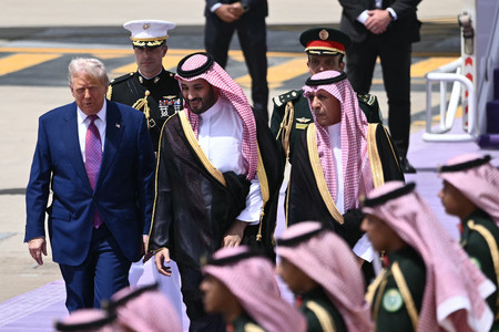 13日、サウジアラビアの首都リヤドに到着したトランプ米大統領(左)を出迎えるムハンマド皇太子(中央)(AFP時事)