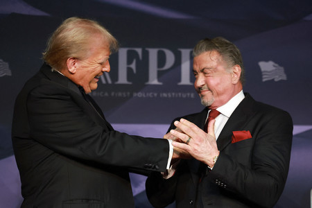 握手するトランプ米大統領(左)と俳優のシルベスター・スタローン氏=2024年11月、米フロリダ州パームビーチ(AFP時事)