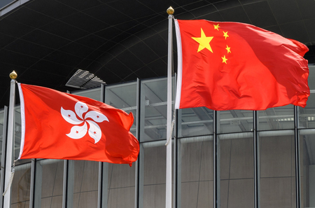 香港旗(左)と中国国旗(AFP時事)