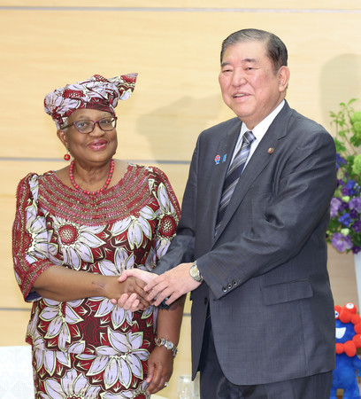 世界貿易機関(WTO)のオコンジョイウェアラ事務局長(左)と握手する石破茂首相=13日、首相官邸