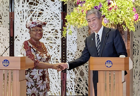 記者会見で握手する世界貿易機関(WTO)のオコンジョイウェアラ事務局長(左)と岩屋毅外相=13日午後、東京都港区