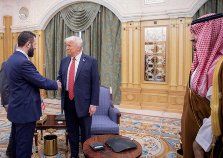 14日、サウジアラビアの首都リヤドで、シリアのシャラア暫定大統領(左)と握手するトランプ米大統領(中央)(サウジ王室提供)(AFP時事)