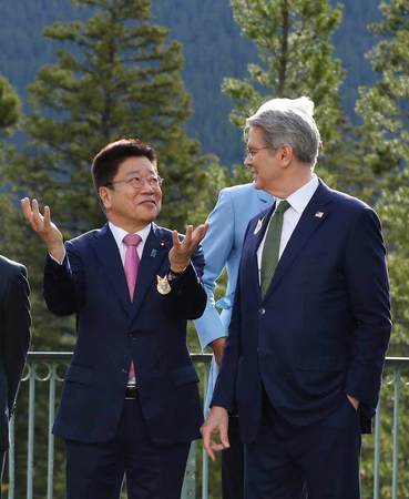 写真撮影の前に会話する加藤勝信財務相(左)とベセント米財務長官=21日、カナダ・バンフ(AFP時事)