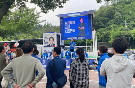 韓国の革新系最大野党「共に民主党」の大統領候補、李在明前代表の応援演説に耳を傾ける人々=23日、南東部・大邱市