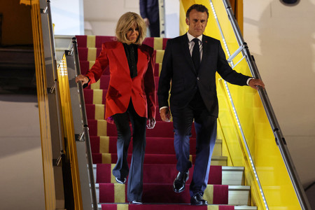 ２５日、ハノイに到着したフランスのマクロン大統領（右）とブリジット夫人（ＡＦＰ時事）