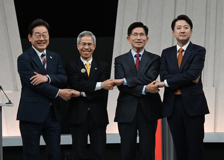27日、ソウルで、韓国大統領選のテレビ討論会を前に写真撮影に応じる「共に民主党」の李在明前代表(左端)、「国民の力」の金文洙前雇用労働相(右から2番目)、「改革新党」の李俊錫議員(右端)ら(AFP時事)