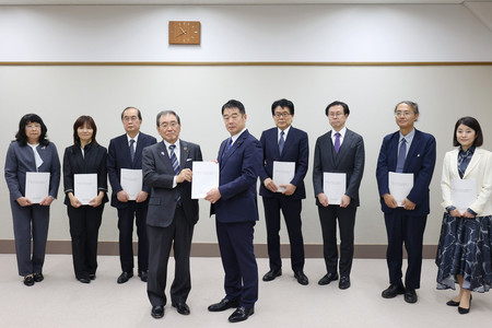 財政制度等審議会の十倉雅和会長(手前左)から建議を受け取る東国幹財務政務官(同右)=27日、東京都千代田区(財務省提供)