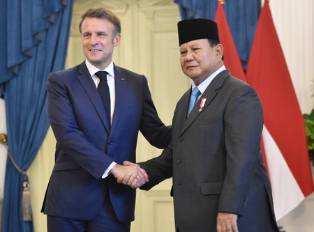 握手するフランスのマクロン大統領(左)とインドネシアのプラボウォ大統領=28日、ジャカルタ