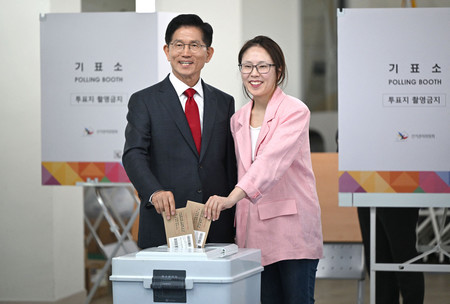 29日、ソウル近郊の仁川市で、娘と共に韓国大統領選の期日前投票を行う保守系与党「国民の力」候補の金文洙前雇用労働相(AFP時事)