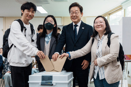 29日、ソウルで、韓国大統領選の期日前投票を行う革新系最大野党「共に民主党」候補の李在明前代表(右から2番目)(AFP時事)