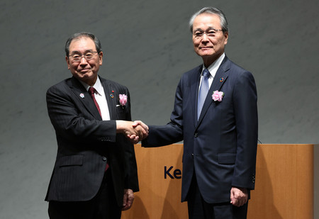 経団連定時総会で握手する十倉雅和前会長（左）と筒井義信新会長＝２９日午後、東京都千代田区