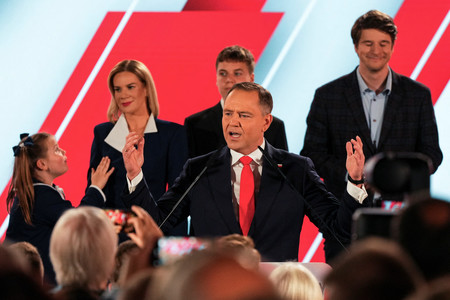 1日、ワルシャワで、ポーランド大統領選決選投票の出口調査の結果を受けて演説するナブロツキ氏(中央)(ロイター時事)
