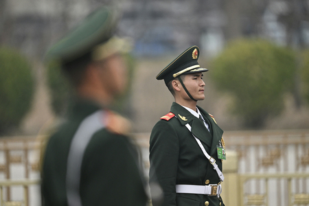 中国・北京の人民大会堂を警備する警察官=3月11日(AFP時事)